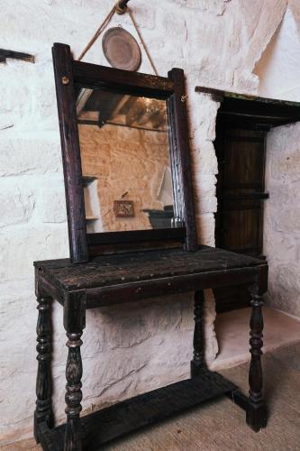a mirror sitting on a stand next to a wall at نزل كوفان التراثي Koofan Heritage Lodge in Salalah