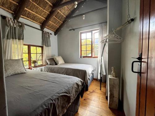 a bedroom with two beds and a window at Comfy Greyton Cottage for Four in Greyton