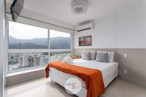 1 dormitorio con cama y ventana grande en Apart Hotel no coração do Leblon, com limpeza diária incluída, en Río de Janeiro