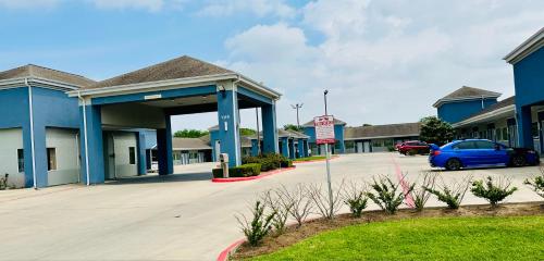 a building with a car parked in a parking lot at Lonestar Inn in El Campo