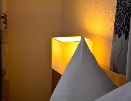 a lamp in a room with a white pillow at Genusshotel Hirschen - Erholung im Grünen (Südschwarzwald) in Sallneck