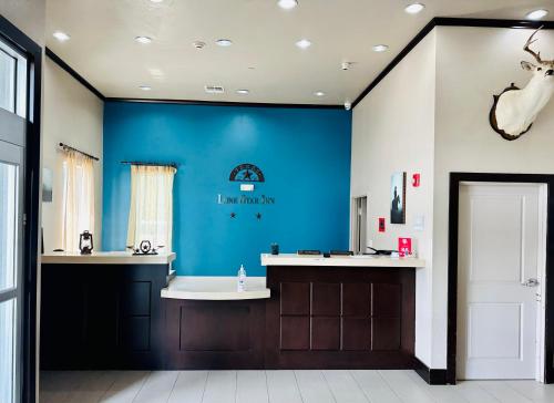 uma casa de banho com uma parede azul e uma banheira em Lonestar Inn em El Campo
