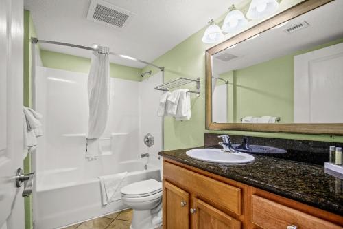 a bathroom with a sink and a toilet and a mirror at The Splendid South Carolina Getaway in Myrtle Beach
