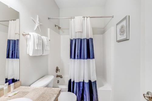 a bathroom with a blue and white shower curtain at EazyBreezy in Rockaway Beach