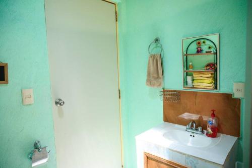 een badkamer met een wastafel en een spiegel bij Casa Hogareña y Artística in Carrillo