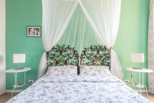 a bedroom with a bed with a canopy and two lamps at Tauromenion Guest House in Taormina