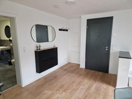 - un salon avec une porte noire et un miroir dans l'établissement Ferienwohnung am Schloß, à Friedrichshafen