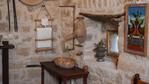 a room with a stone wall with a table and mirrors at نزل كوفان التراثي Koofan Heritage Lodge in Salalah
