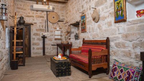 a living room with a couch and a stone wall at نزل كوفان التراثي Koofan Heritage Lodge in Salalah