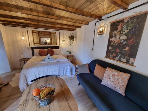 a bedroom with a bed and a table and a couch at El Nido Fuente Hervera. Precioso Loft con Bañera de Hidromasaje in Vega de San Mateo