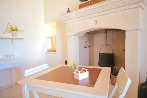 comedor con mesa y chimenea en Masseria Donna Palma b&b, en Pezze di Greco