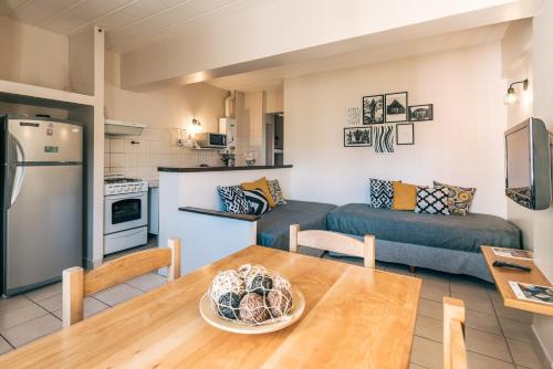 a kitchen and living room with a table and a couch at Riviera Fueguina Apartments in Ushuaia