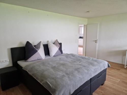 - une chambre avec un lit doté d'oreillers violets et blancs dans l'établissement Ferienwohnung am Schloß, à Friedrichshafen