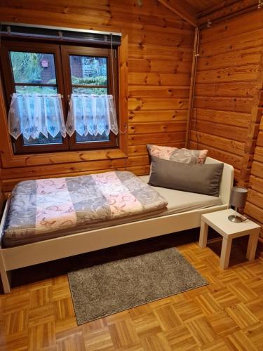 Ce lit se trouve dans une chambre en bois dotée d'une fenêtre. dans l'établissement Ferienhaus Kellers Finkennest, à Braunfels