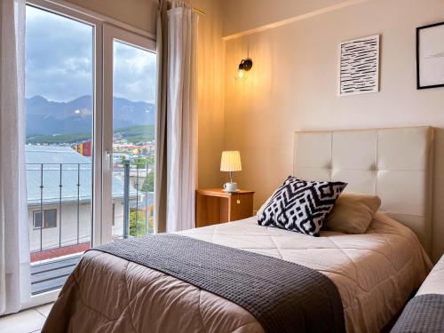 a bedroom with a bed and a large window at Riviera Fueguina Apartments in Ushuaia