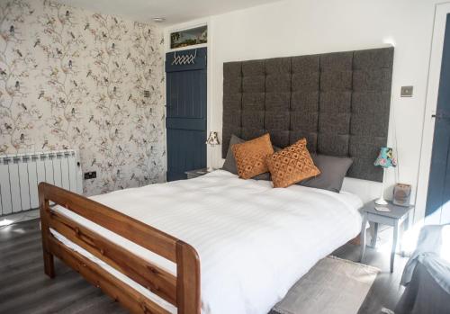 a bedroom with a large white bed with a large headboard at Borthwick Farm Cottage Annex in Gorebridge