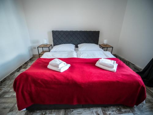 1 dormitorio con 1 cama roja y 2 toallas en Apartmán Sportovců 9 en Kutná Hora