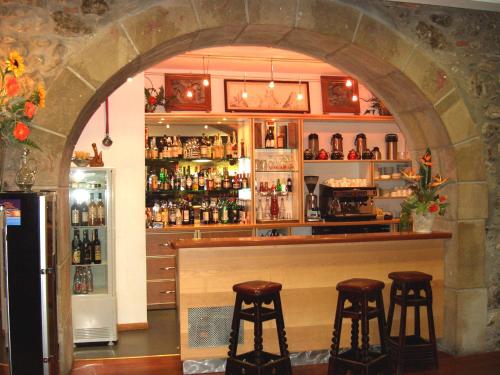 a bar with two stools in front of a counter at Logis Hôtel Restaurant de la Poste in Tarascon-sur-Ariège