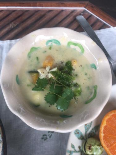 a bowl of soup with broccoli and greens in it at Travelers House おーさんてぃん青空舎 in Taketomi