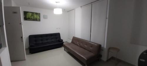 een woonkamer met een bank en een stoel bij Apartamento Villavicencio in Villavicencio
