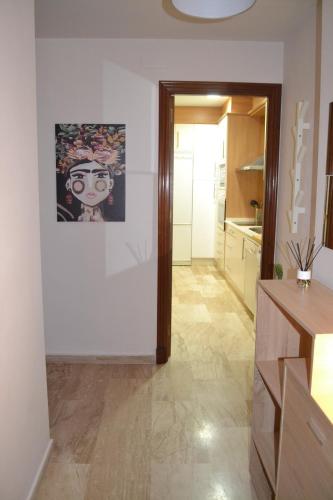 a hallway of a kitchen with a painting on the wall at Apartamento Posidonia Free Parking in Cádiz