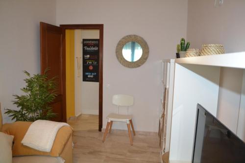 a living room with a couch and a chair and a mirror at Apartamento Posidonia Free Parking in Cádiz