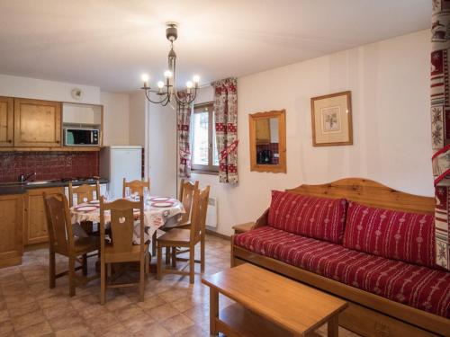 un salon avec un canapé rouge et une table dans l'établissement Appartement spacieux au pied des pistes pour 6 personnes, Lanslevillard-Val Cenis - FR-1-508-11, à Lanslevillard