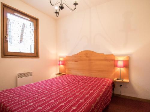 - une chambre avec un lit rouge et deux lampes dans l'établissement Appartement spacieux au pied des pistes pour 6 personnes, Lanslevillard-Val Cenis - FR-1-508-11, à Lanslevillard