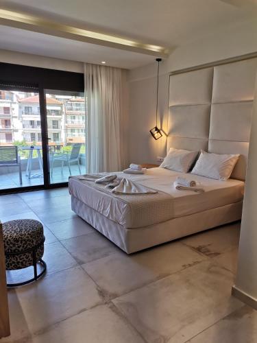a bedroom with a large bed and a balcony at Thetis Boutique Apartments in Neos Marmaras