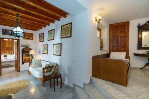 a bedroom with a bed and a chair in a room at Captain D - Hydra Dream Houses in Hydra