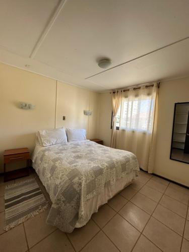 a bedroom with a large bed and a window at Cabañas Florencia La Serena in La Serena