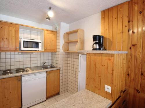 - une petite cuisine avec des placards en bois et un four micro-ondes dans l'établissement Appartement à Val Cenis Lanslebourg, 300m des pistes, 7 pers, balcon sud et garage - FR-1-508-3, à Lanslebourg-Mont-Cenis