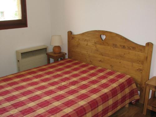 - une chambre avec un lit en bois et une couverture tressée dans l'établissement Appartement à Val Cenis Lanslebourg, 300m des pistes, 7 pers, balcon sud et garage - FR-1-508-3, à Lanslebourg-Mont-Cenis
