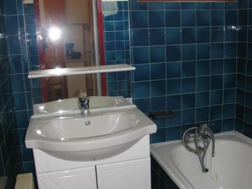 une salle de bain carrelée bleue avec un lavabo et une baignoire dans l'établissement Appartement à Val Cenis Lanslebourg, 300m des pistes, 7 pers, balcon sud et garage - FR-1-508-3, à Lanslebourg-Mont-Cenis