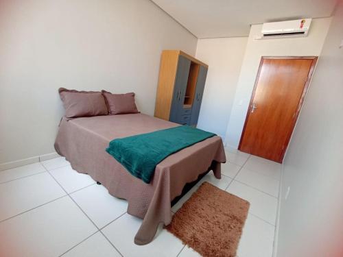 a small bedroom with a bed with a green blanket at 101-APT-Espaço,conforto.È disso que você precisa! in Anápolis