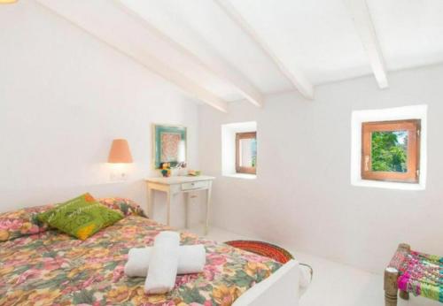 a white bedroom with a cross on a bed at Toscana in Benissa