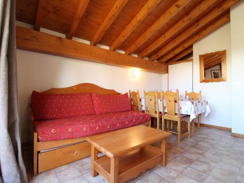 a living room with a red couch and a table at Appartement Lanslevillard, 3 pièces, 6 personnes - FR-1-508-72 in Lanslevillard