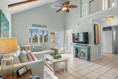 a living room with a couch and a tv at Paradise Duplex B in Gulf Shores
