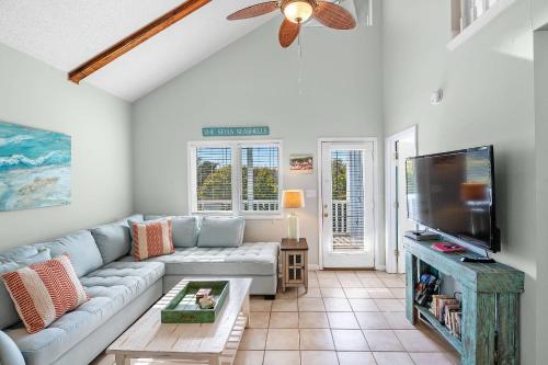 a living room with a couch and a flat screen tv at Paradise Duplex B in Gulf Shores