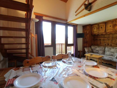 une table de salle à manger avec des assiettes et des verres dessus dans l'établissement Duplex pour 8 pers avec balcon et wifi au pied des pistes - FR-1-508-79, à Termignon