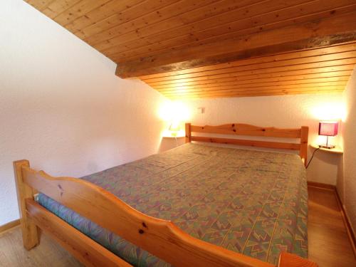 - un lit en bois dans une chambre avec deux lampes dans l'établissement Duplex pour 8 pers avec balcon et wifi au pied des pistes - FR-1-508-79, à Termignon