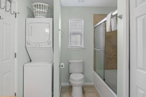 a white bathroom with a toilet and a shower at Paradise Duplex B in Gulf Shores