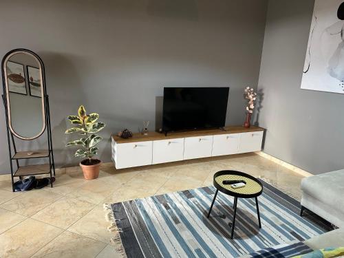 a living room with a flat screen tv on a white cabinet at Marlis' Home in Golem