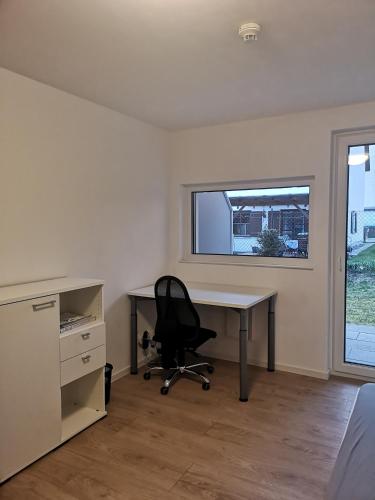un bureau avec un bureau, une chaise et une fenêtre dans l'établissement Beautiful flat ,WIFI , easy parking, à Ingolstadt