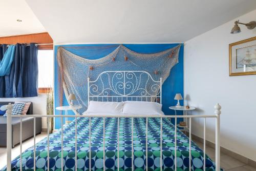 ein blaues Schlafzimmer mit einem Bett mit blauem Kopfteil in der Unterkunft Tauromenion Guest House in Taormina