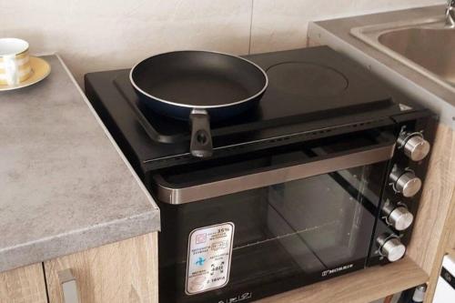a frying pan on top of a stove in a kitchen at Quiet Studio with Athens View in Athens