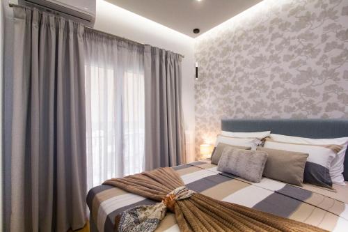 Luxurious apt near Ampelokipoi Metro station في أثينا: غرفة نوم بسرير مع نافذة كبيرة