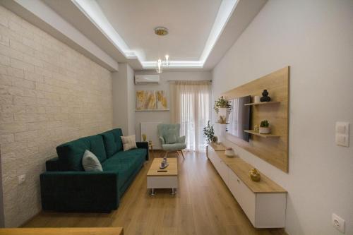 a living room with a green couch and a table at Luxurious apt near Ampelokipoi Metro station in Athens