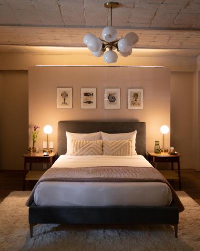a bedroom with a large bed with two tables and a ceiling at Casa Seis Siete in Mexico City