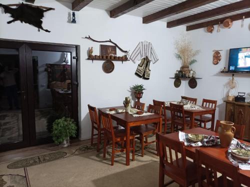uma sala de jantar com mesas e cadeiras de madeira em Pensiunea La Poarta Bucovinei em Suceava